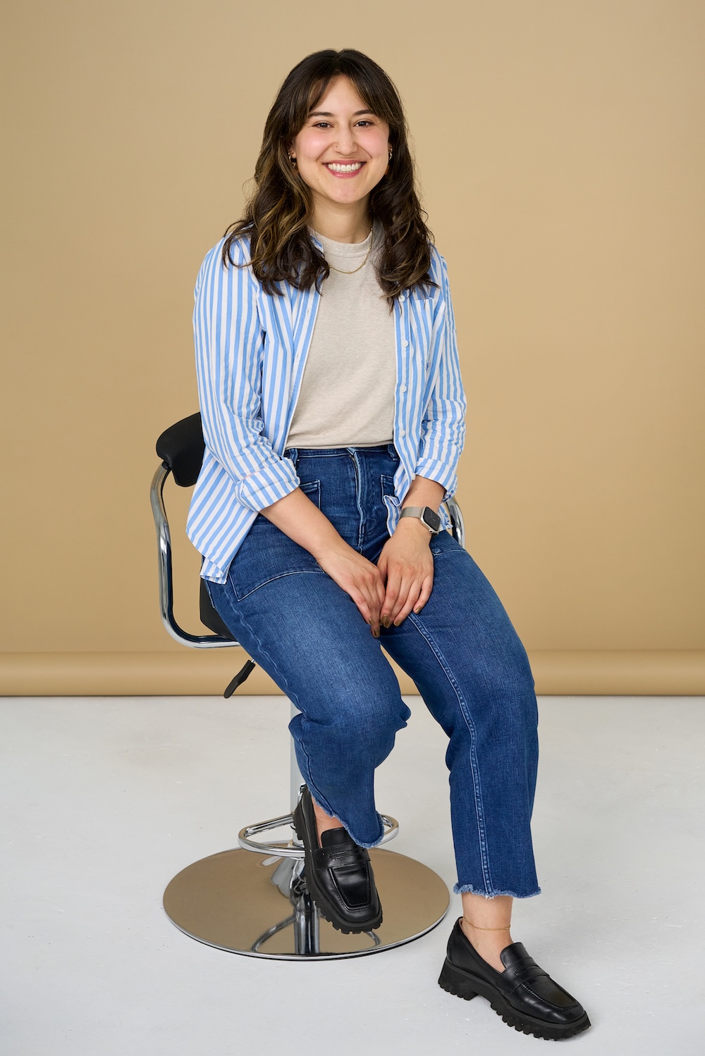 Alex Lash sitting on a chair in a t-shirt and jeans.